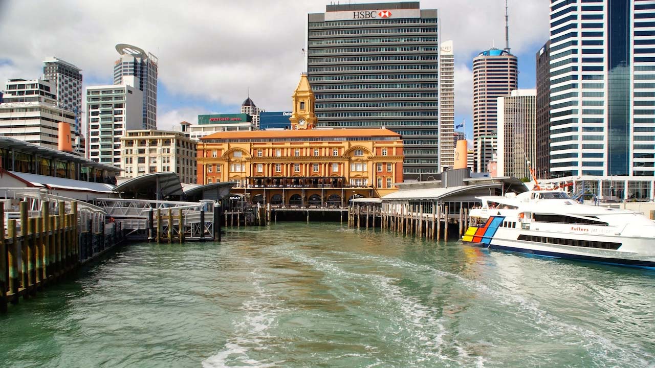 Boats docked in the harbour in Auckland with a backdrop of buildings