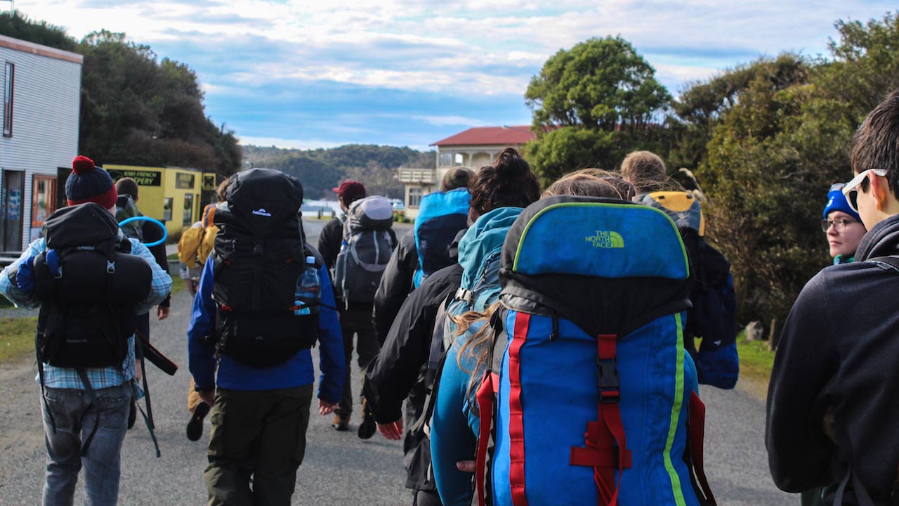 A large group of people walking with backpacks in Dunedin, New Zealand