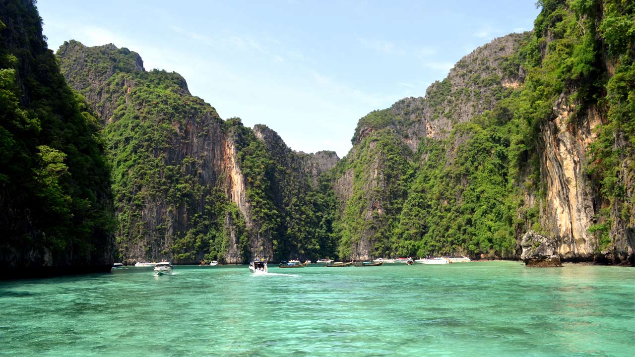 Crystal clear ocean surrounded by limestone cliffs near Railay Beach in Thailand
