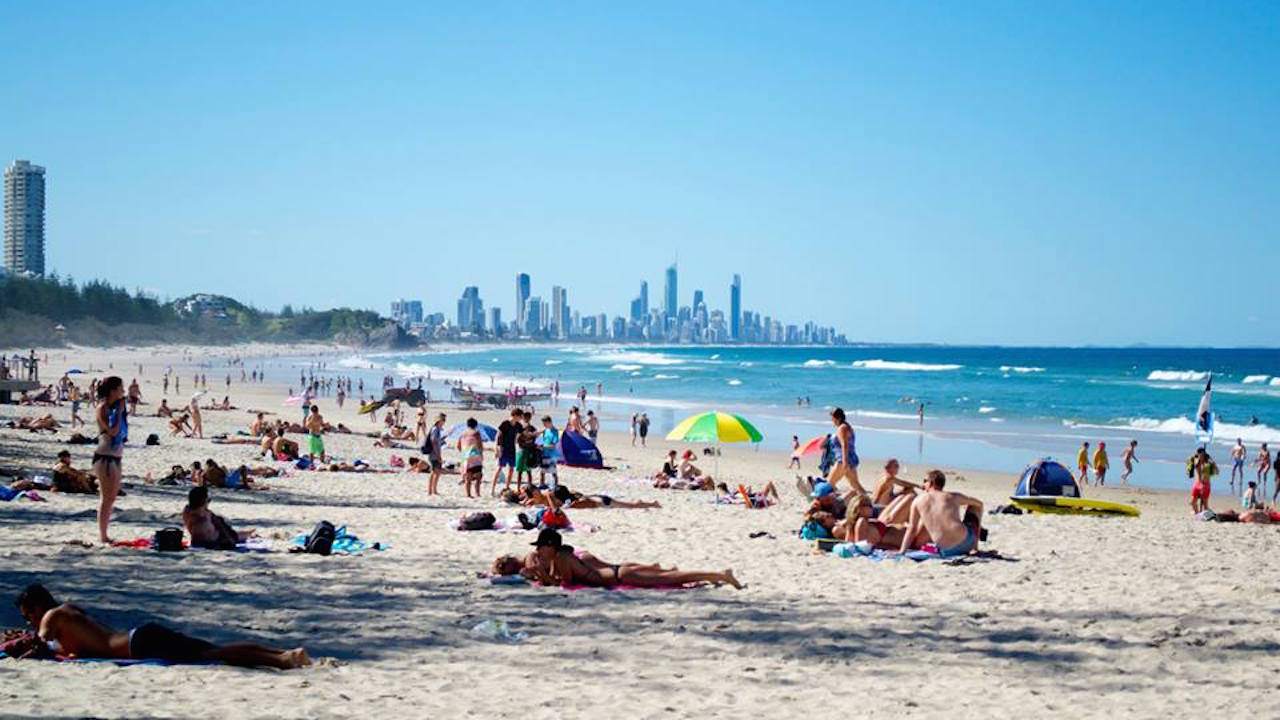 Crowds of people enjoying the Gold Coast's beautiful beach on a sunny day