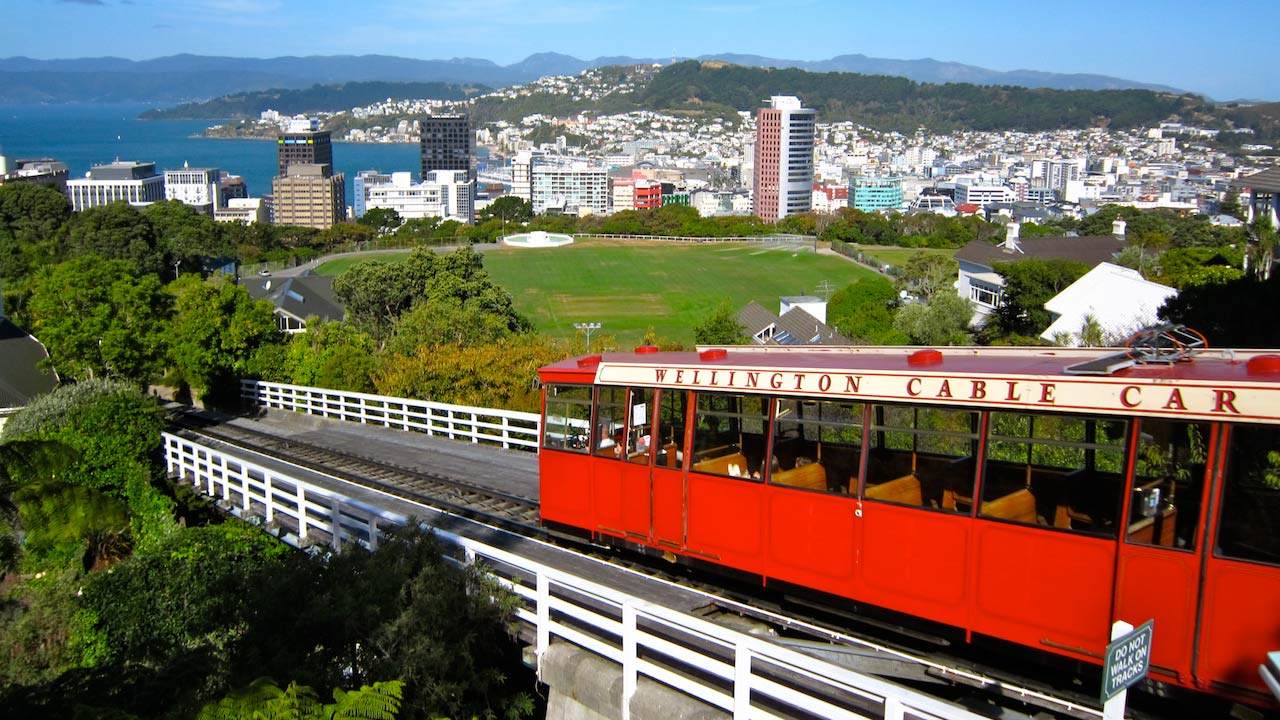 A red cable car traveling outside Wellington, New Zealand