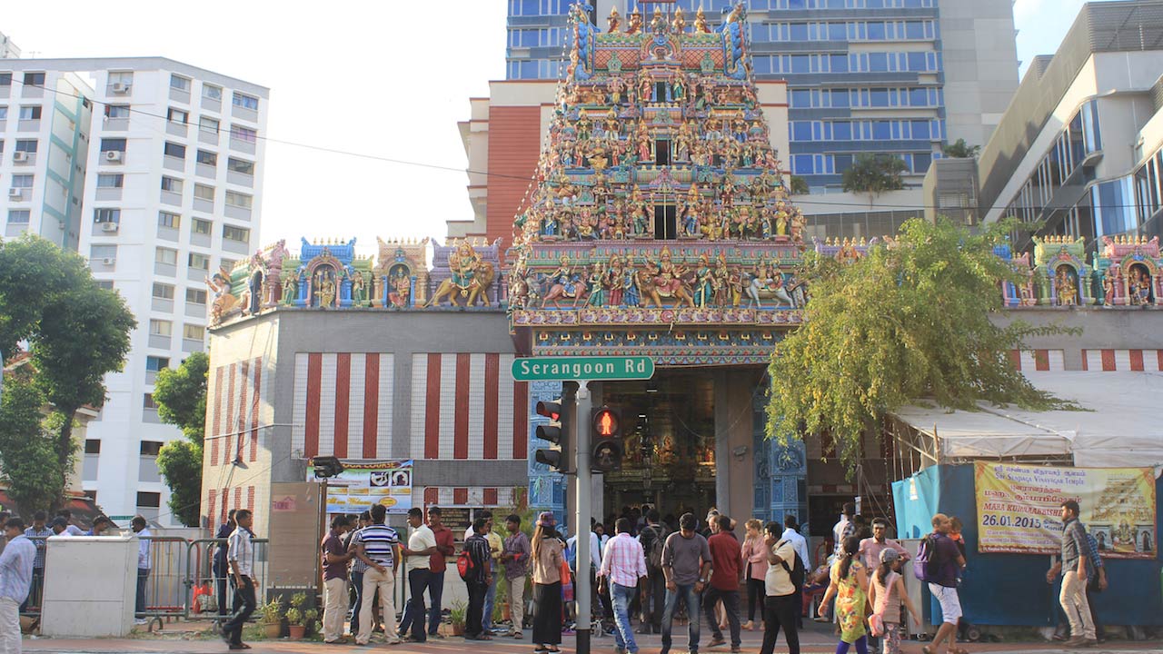 Crowds of people walking near a temple in Singapore