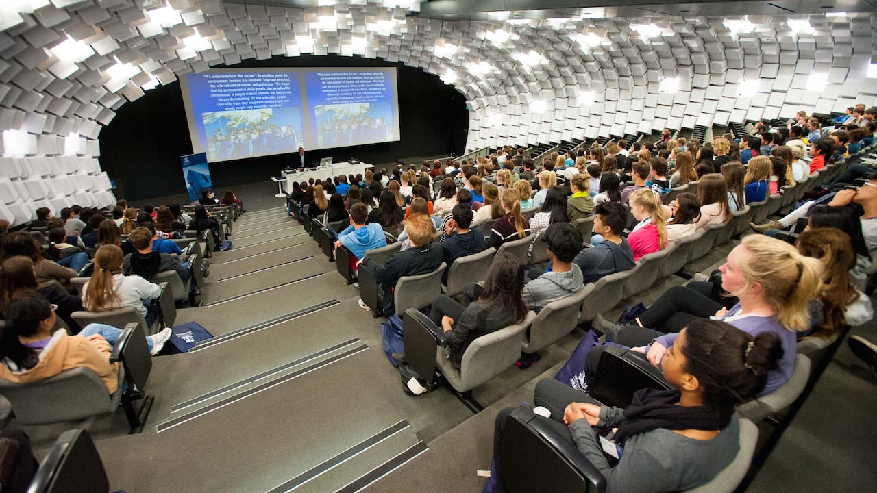 A packed lecture hall with students listening attentively to the professor at University of Melbourne