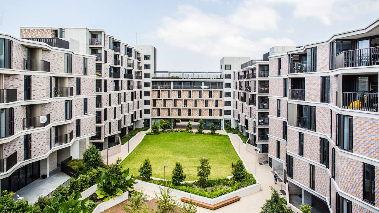 UNSW's modern housing complex, with buildings on three sides and a grass lawn in the middle