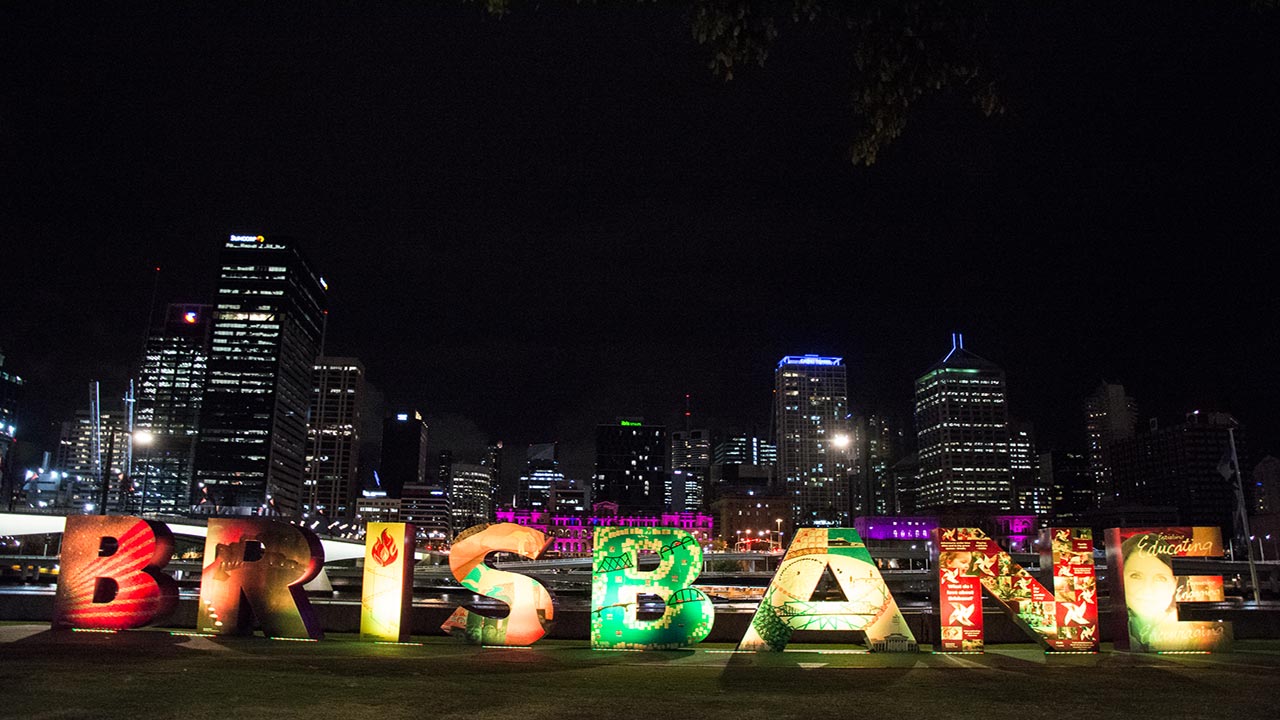 Brisbane's nighttime cityscape illuminated behind the city's colorful, lifesized 'Brisbane' letters