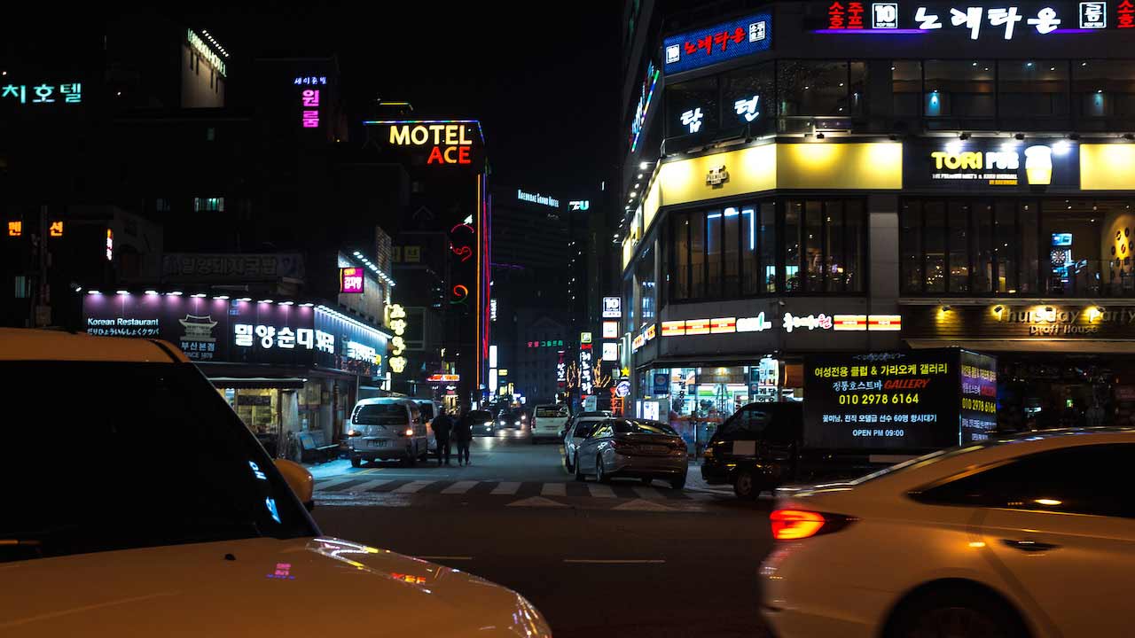 Illuminated buildings and taxis driving by at night in Korea