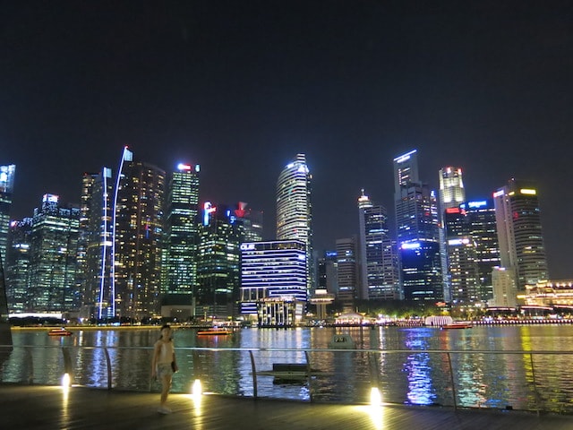 An illuminated Singapore skyline reflected in the harbor
